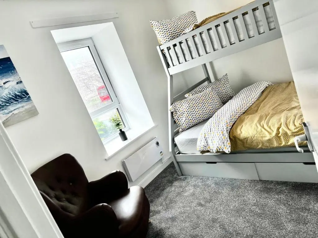 a small bedroom with a bunk bed and a mirror at Harbour View Hopeman in Hopeman