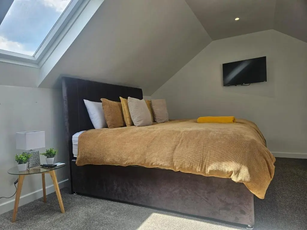 a bedroom with a bed with a tv on the wall at THE KEMPS 7bed 6 bathroom PARKING for 3 vehicles Ideal for contractors Next to LIDLE part of Langleycottageandapartments portfolio REDUCTION FOR LONG STAYS in Inverness