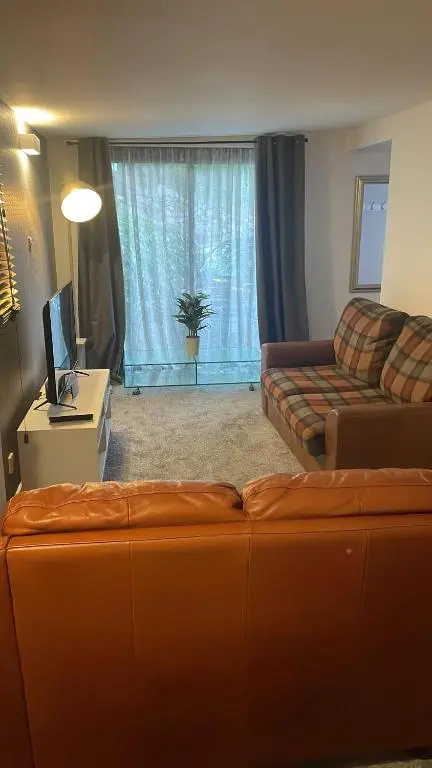 a living room with a couch and a television at Casale Peterculter in Peterculter