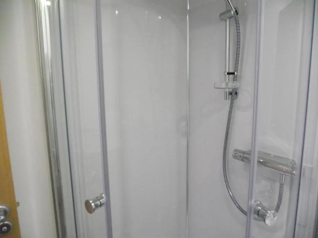 a shower stall with a glass door with a shower at 6B Church St. Dingwall Apartment in Dingwall