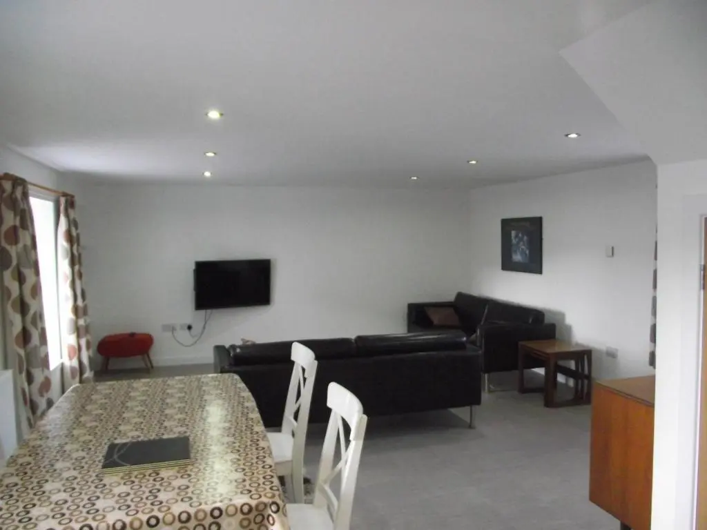 a living room with a table and a couch at 6B Church St. Dingwall Apartment in Dingwall
