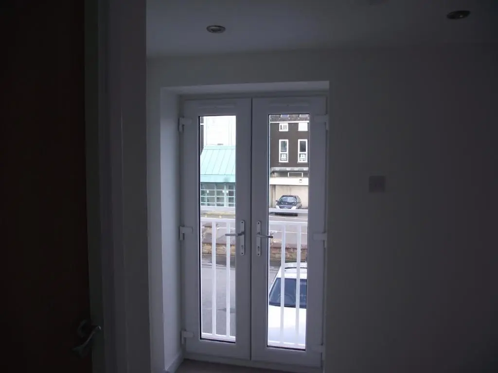 an open door with a view of a building at 6B Church St. Dingwall Apartment in Dingwall