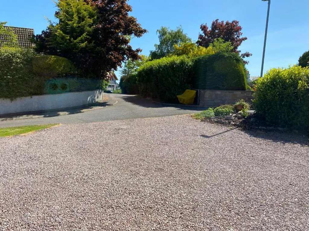 a gravel driveway with bushes on the side of a road at Stagstone apartment in Fortrose in Fortrose