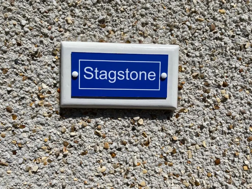 a sign on a stone wall with the word stigma at Stagstone apartment in Fortrose in Fortrose
