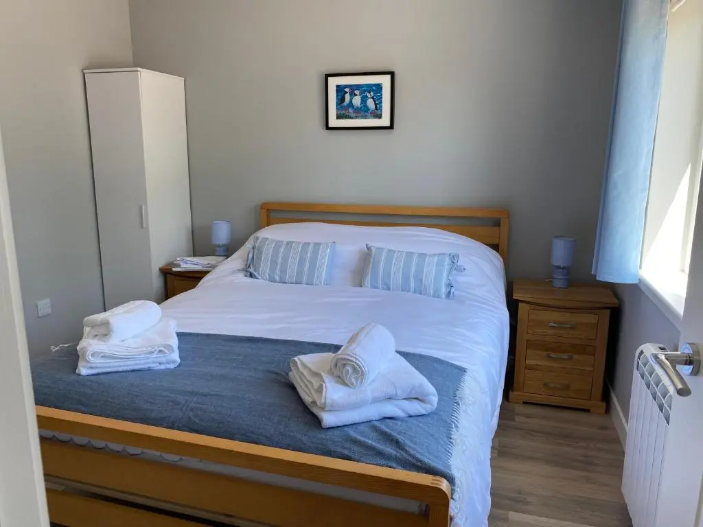 a bedroom with a bed with two towels on it at Stagstone apartment in Fortrose in Fortrose