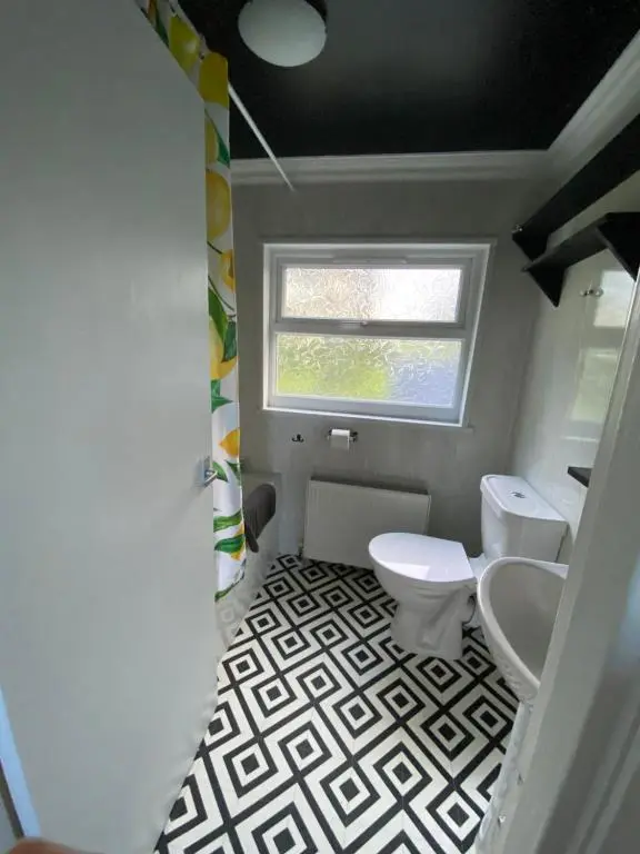a bathroom with two toilets and a window at Struan Cottage in Knockandhu