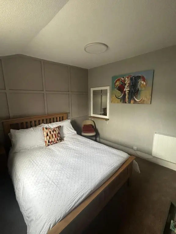 a bedroom with a large bed with white sheets at The Barrel in Ballater