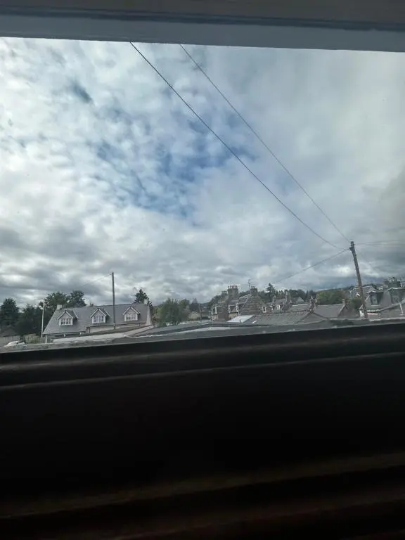 a view from a car window of a street with houses at The Barrel in Ballater