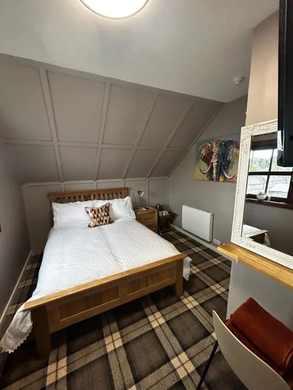 a bedroom with a large bed in a attic at The Barrel in Ballater