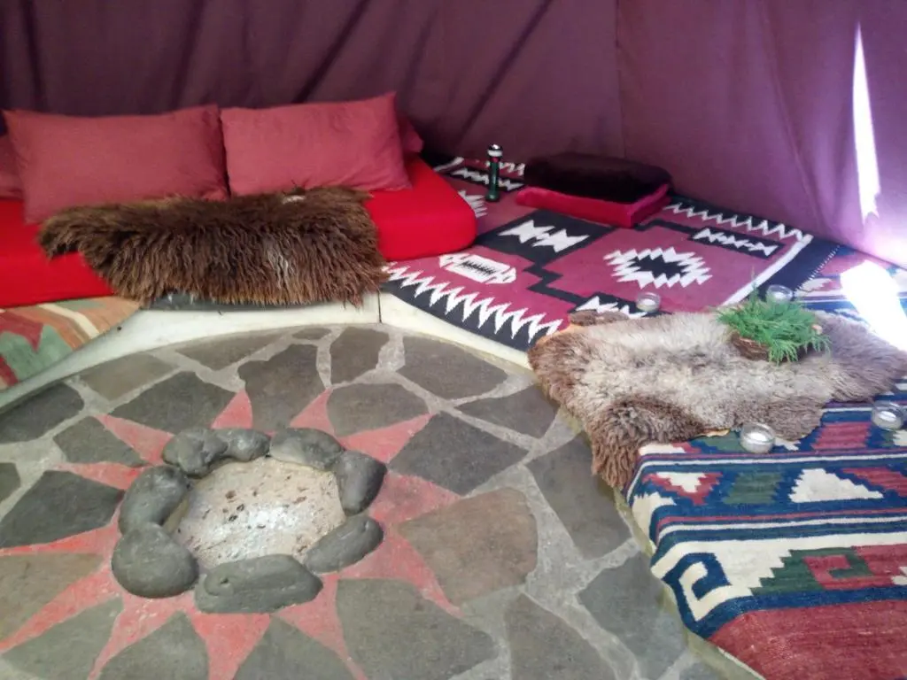 a living room with a couch and a rug at Private Speyside Tipi Retreat and Whisky Marrying Tun Hot Tub in Coltfield