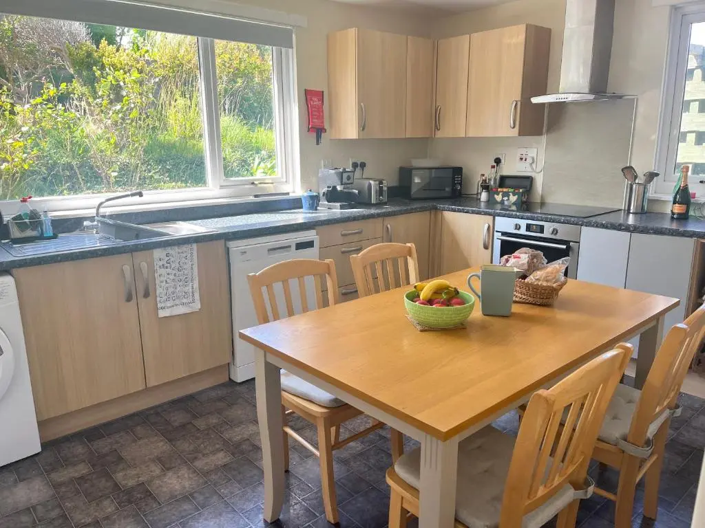 a kitchen with a wooden table with a bowl of fruit on it at House By The Sea in Portsoy