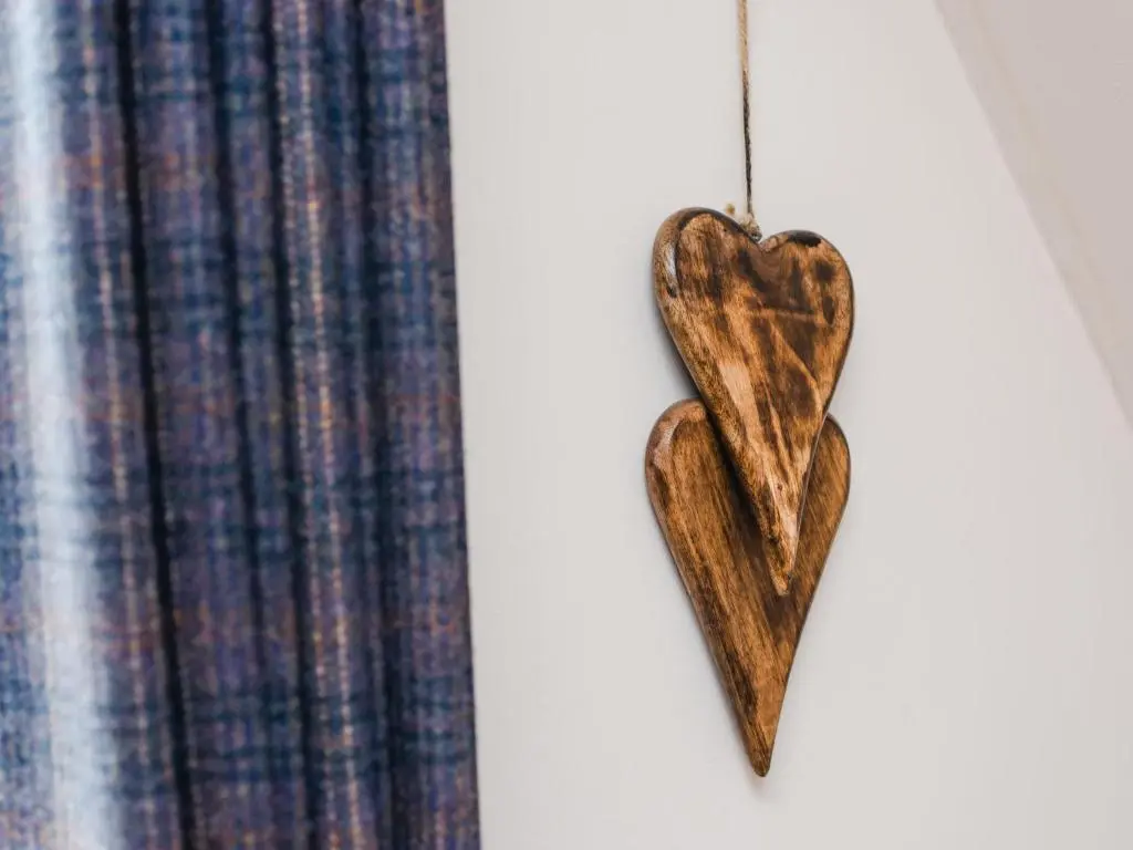 a wooden heart hanging on a wall next to a curtain at Chalet Heron Lodge by Interhome in Spean Bridge
