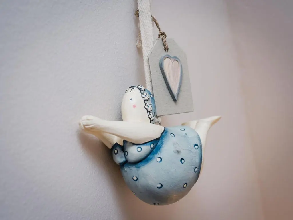 a bird ornament hanging on a wall with a heart at Chalet Heron Lodge by Interhome in Spean Bridge