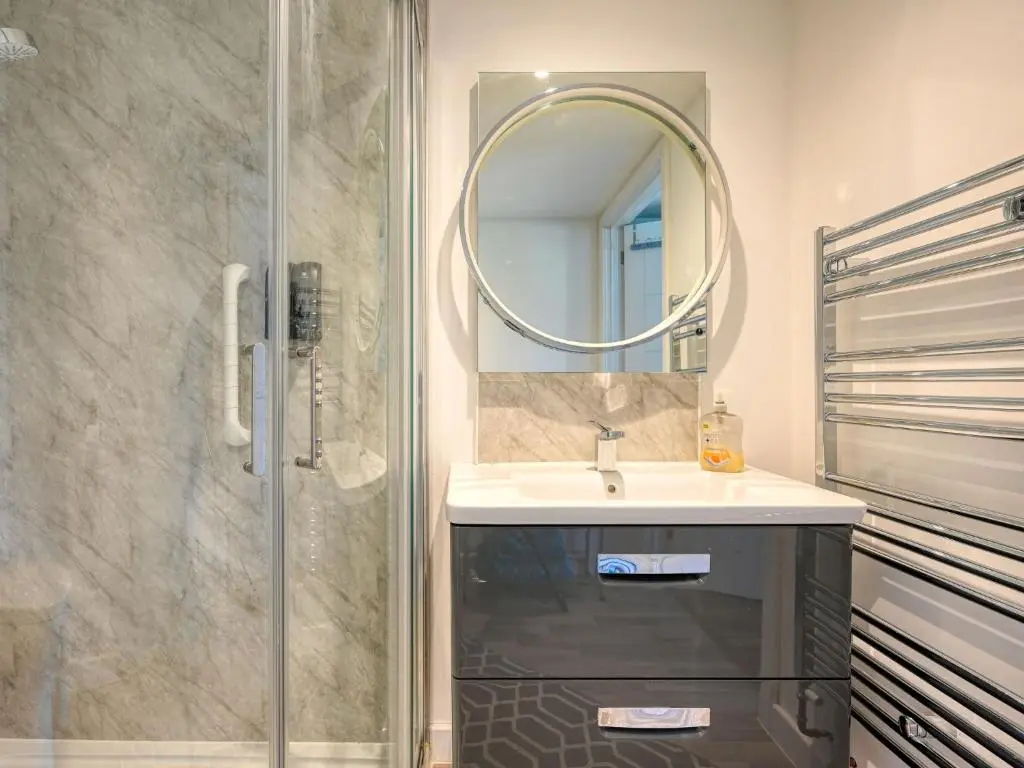 a bathroom with a sink and a shower with a mirror at Studio Crofters View by Interhome in Inverness