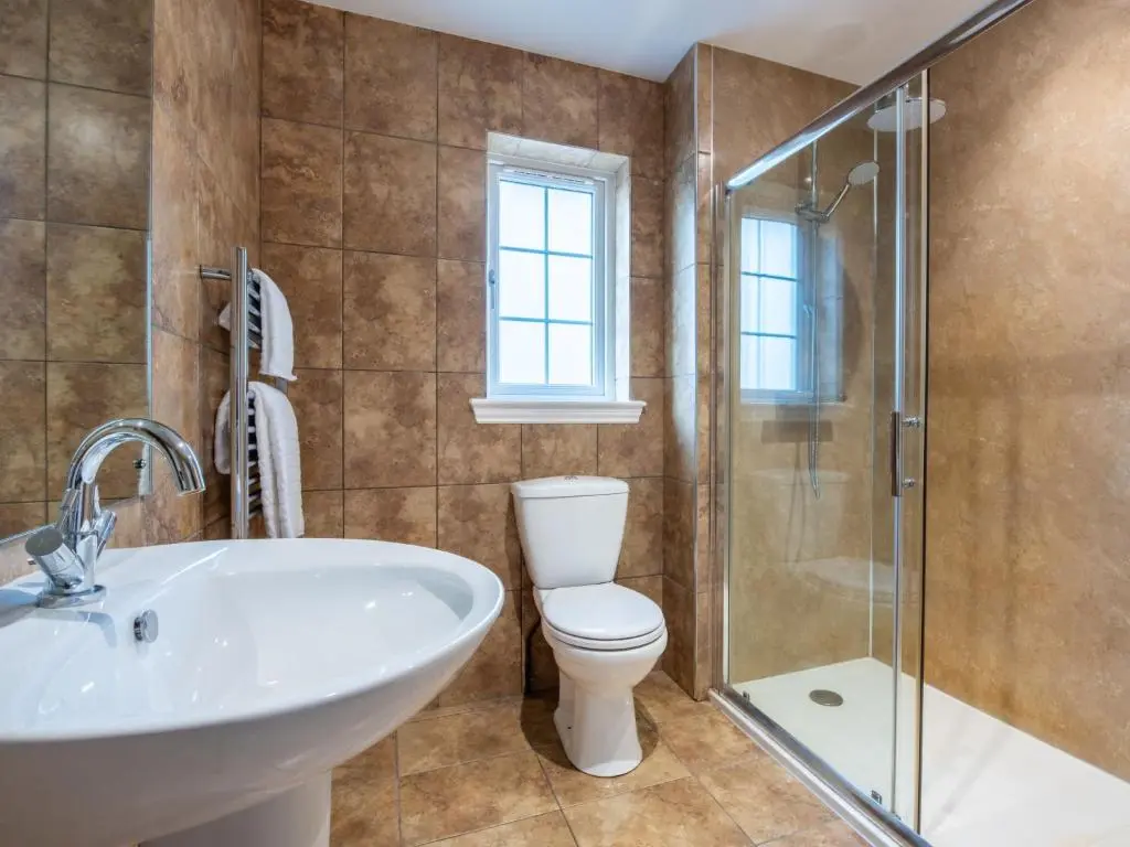 a bathroom with a toilet and a sink and a shower at Holiday Home Mountain View Lodge by Interhome in Whitebridge