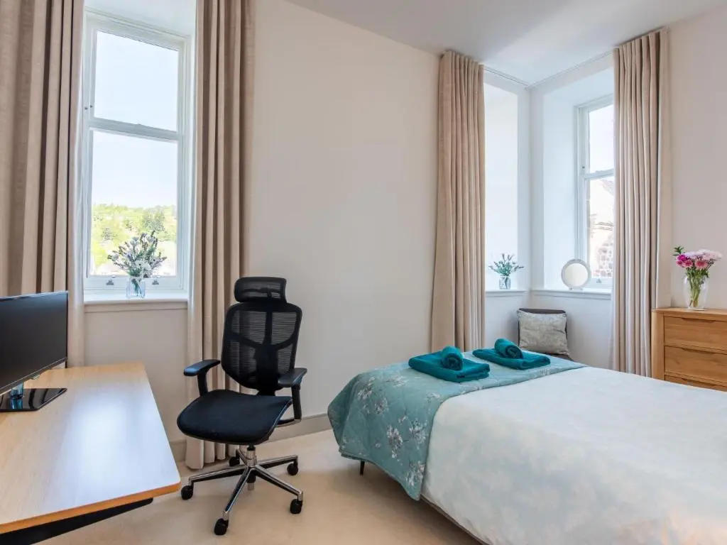 a bedroom with a bed and a desk and a chair at Apartment Great Glen View by Interhome in Inverness