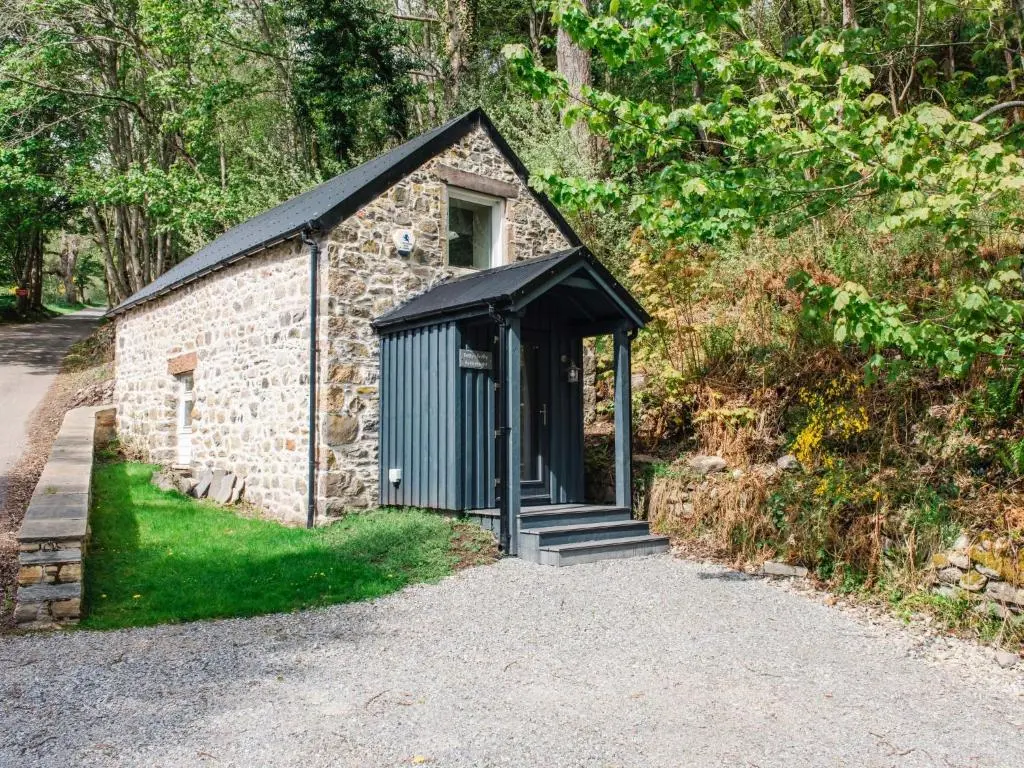 a small stone building with a black roof at Holiday Home Betty's Bothy by Interhome in Drumnadrochit