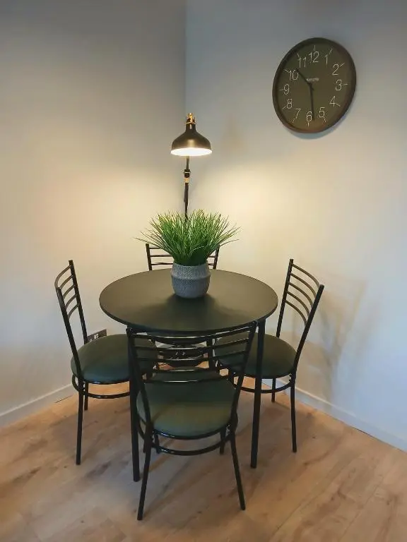 a dining room table with chairs and a clock on the wall at Modern ground floor flat, Inverness city in Inverness