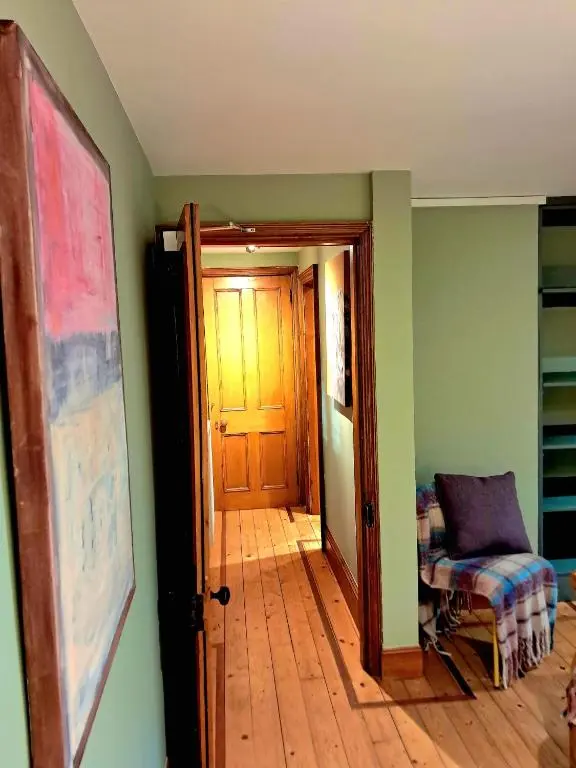 a hallway with a door and a chair in a room at Apartment 42b by the river in Inverness