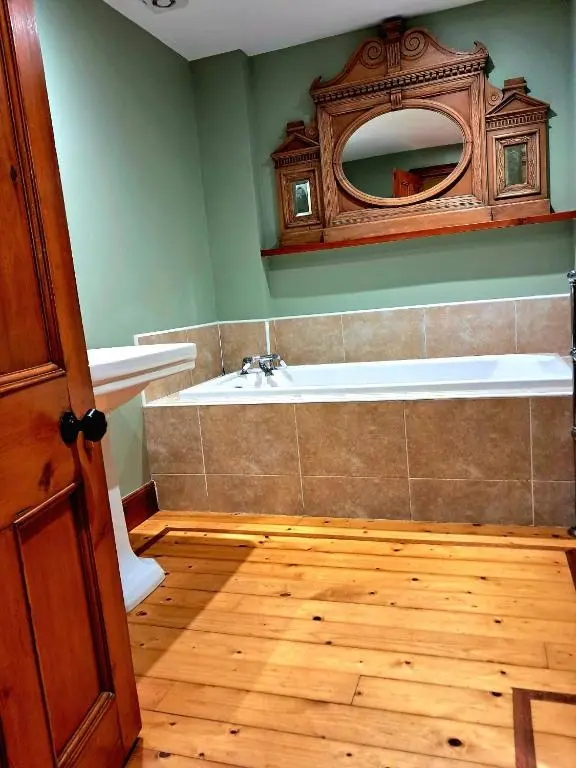 a bathroom with a bath tub and a mirror at Apartment 42b by the river in Inverness