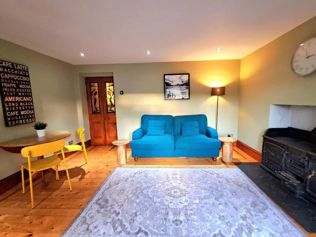 a living room with a blue couch and a table at Apartment 42b by the river in Inverness