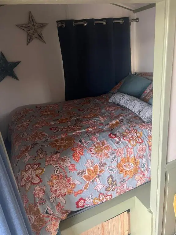a bedroom with a bed with a colorful comforter at Shephards Hut by the Beach in Findhorn