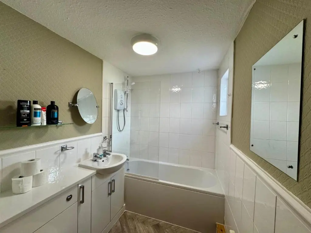 a bathroom with a tub and a sink and a bath tub at The Ivy Nest, central in Inverness