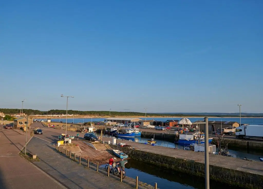 a marina with boats in the water next to a harbor at The Sandpiper in Burghead