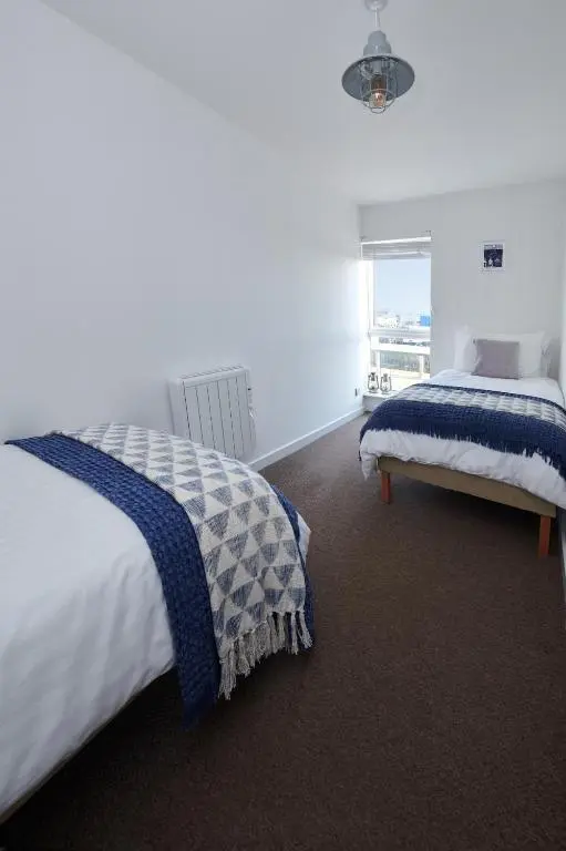 a bedroom with a bed and a window at The Sandpiper in Burghead