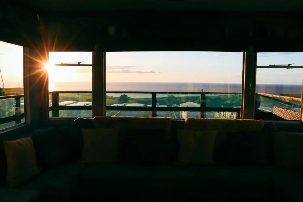 a view of the ocean from a room with a couch at Caravan Nr 51 Only for Family Holiday
