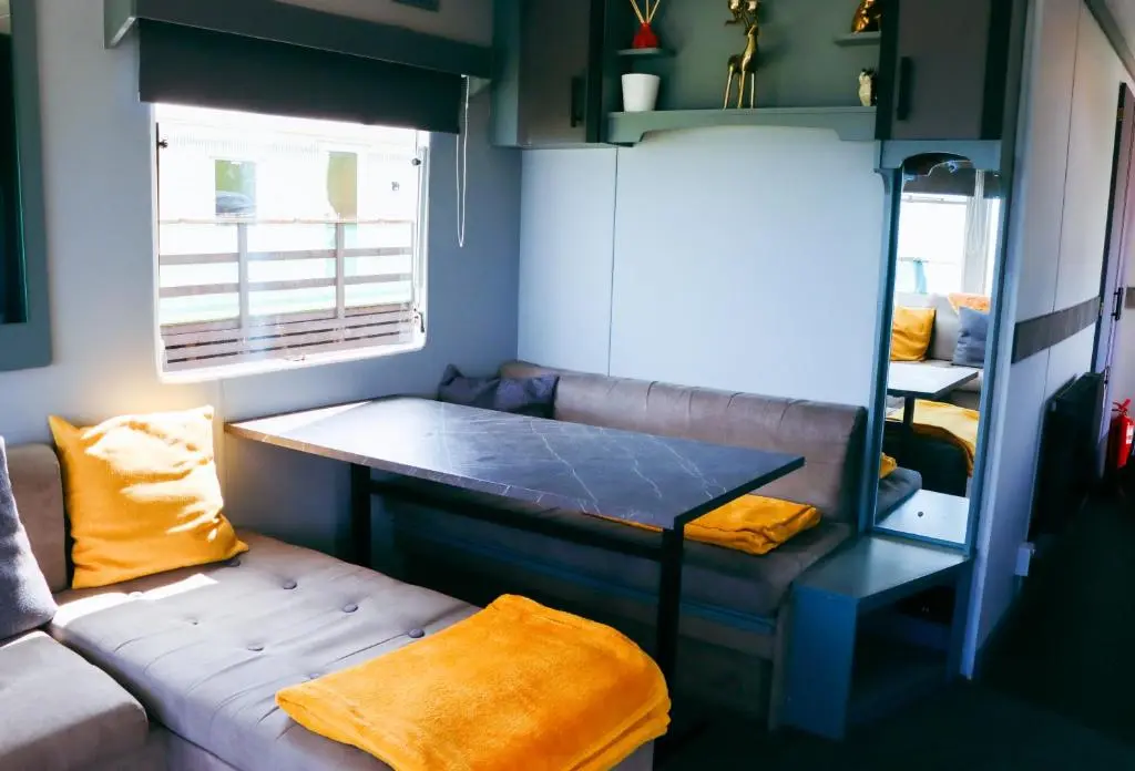 a small room with a couch and a table at Caravan Nr 51 Only for Family Holiday