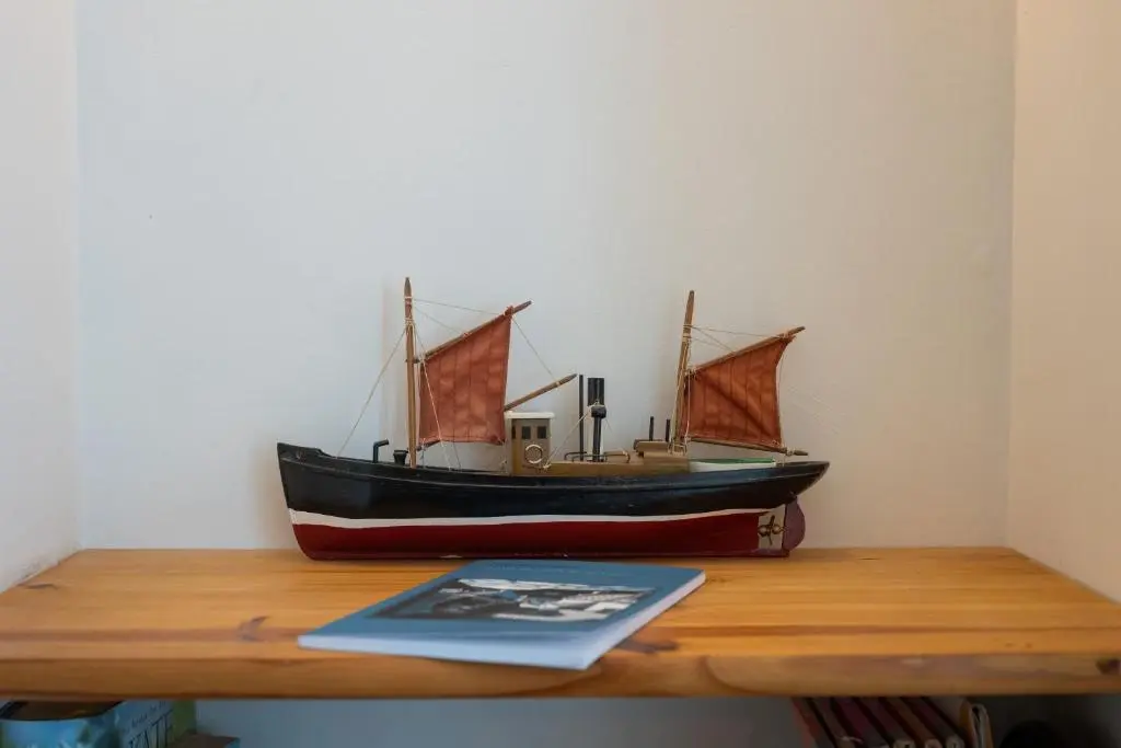 a toy boat sitting on top of a wooden table at Seabreeze Cottage, 17 Seatown, Gardenstown in Gardenstown