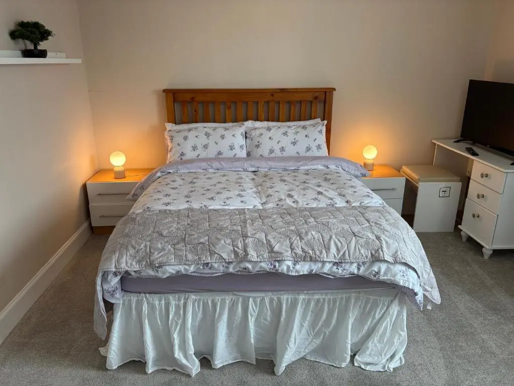 a bedroom with a bed with two night stands and a television at Apartment in Inverness in Inshes