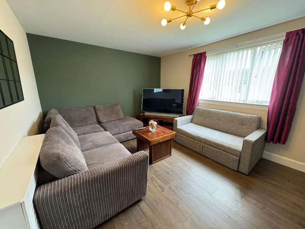 a living room with a couch and a tv at Apartment in Inverness in Inshes
