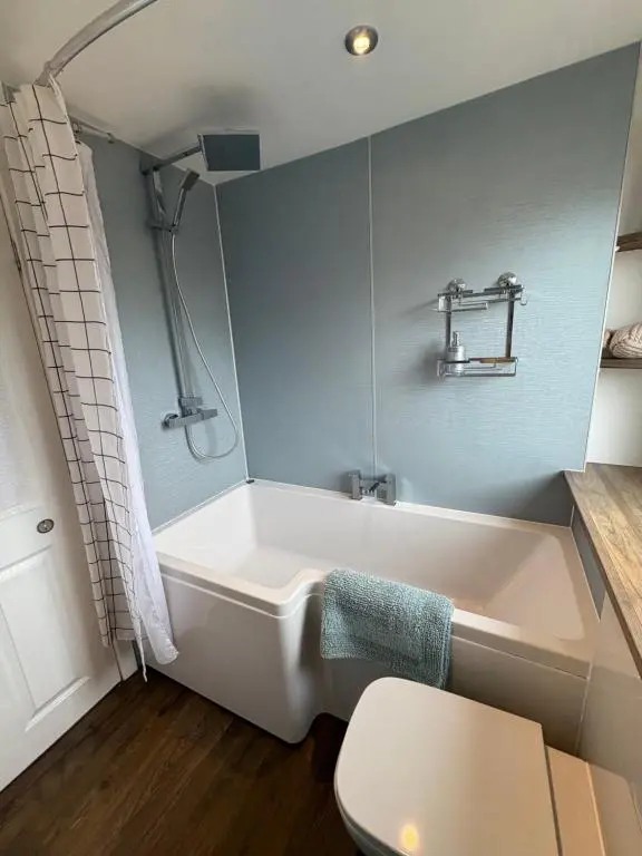 a bathroom with a white tub and a toilet at Apartment in Inverness in Inshes