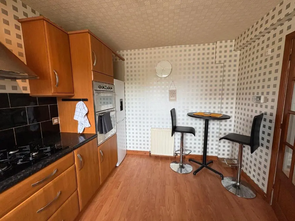 a kitchen with two bar stools in a room at Apartment in Inverness in Inshes