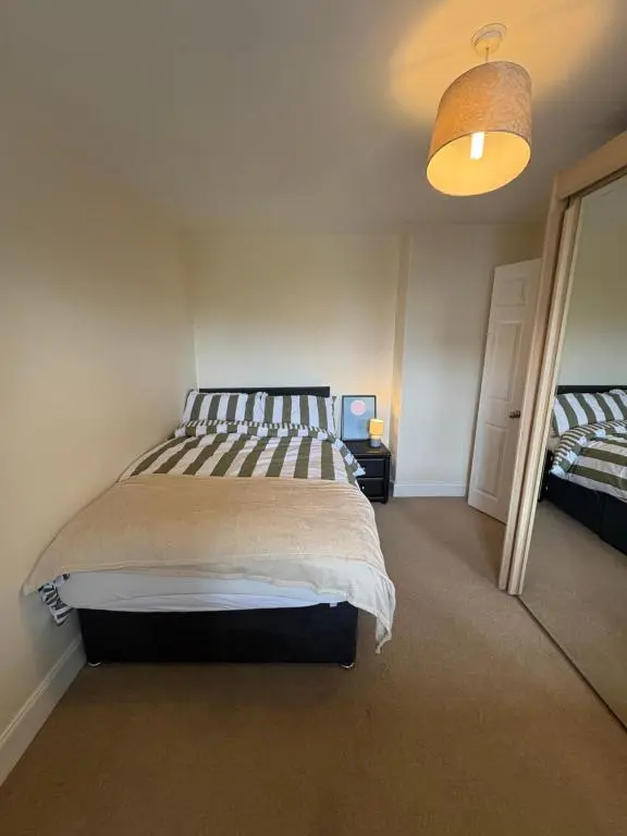 a bedroom with a large bed and a lamp at Apartment in Inverness in Inshes