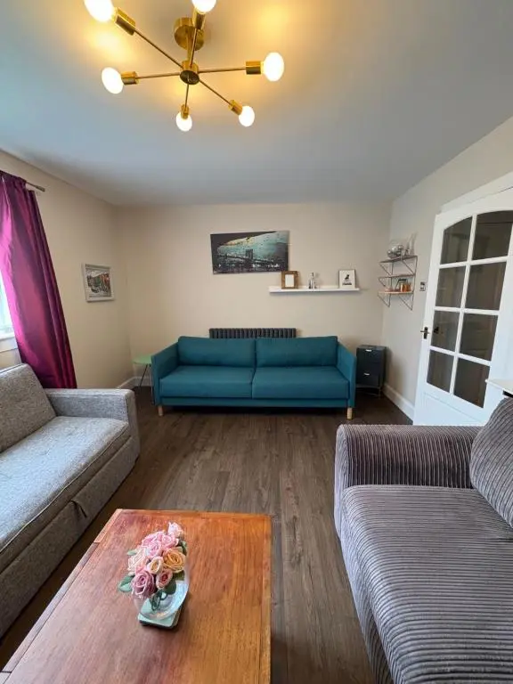 a living room with two couches and a table at Apartment in Inverness in Inshes