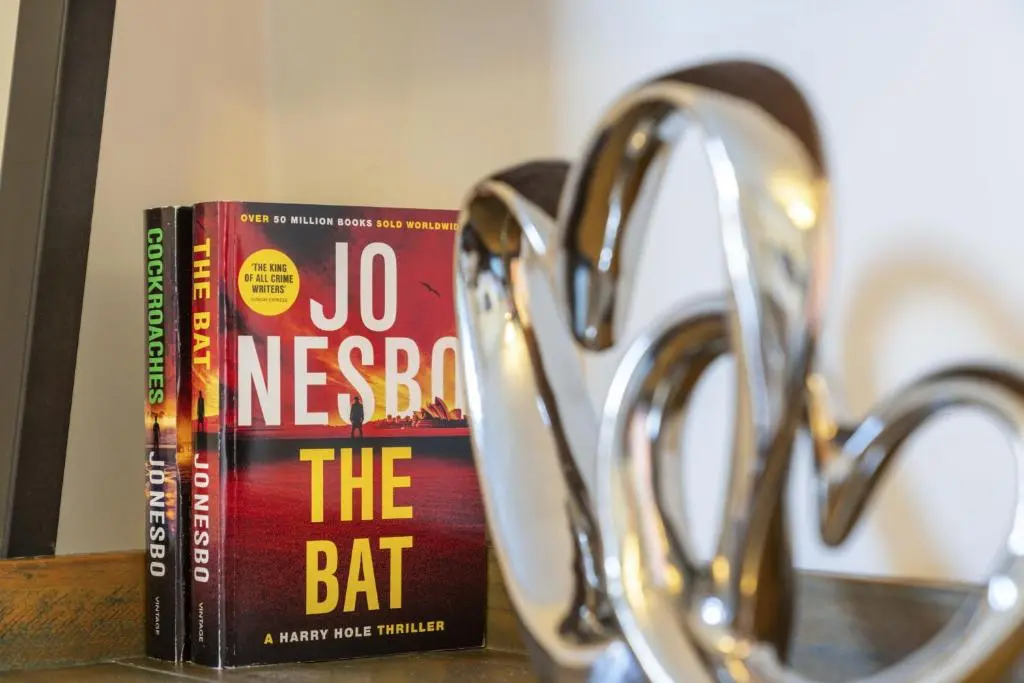 two books on a counter next to a pair of scissors at mySTAYINN Cedar Villa 9 Bedroom House - Inverness in Inverness