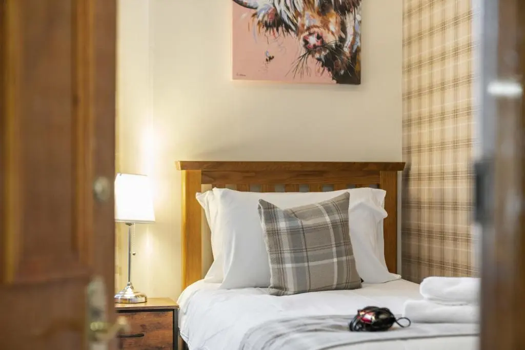 a bedroom with a bed with a pillow at mySTAYINN Cedar Villa Guest House in Inverness