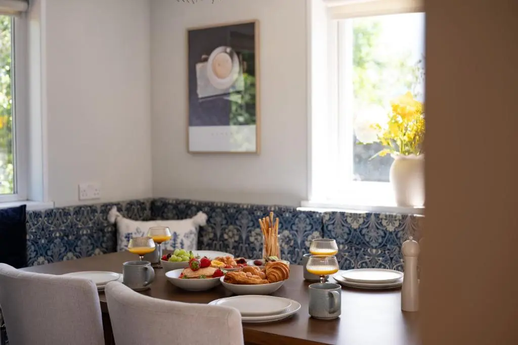 a dining room table with food and glasses of wine at The Garden Cottage with Hot Tub in Portsoy