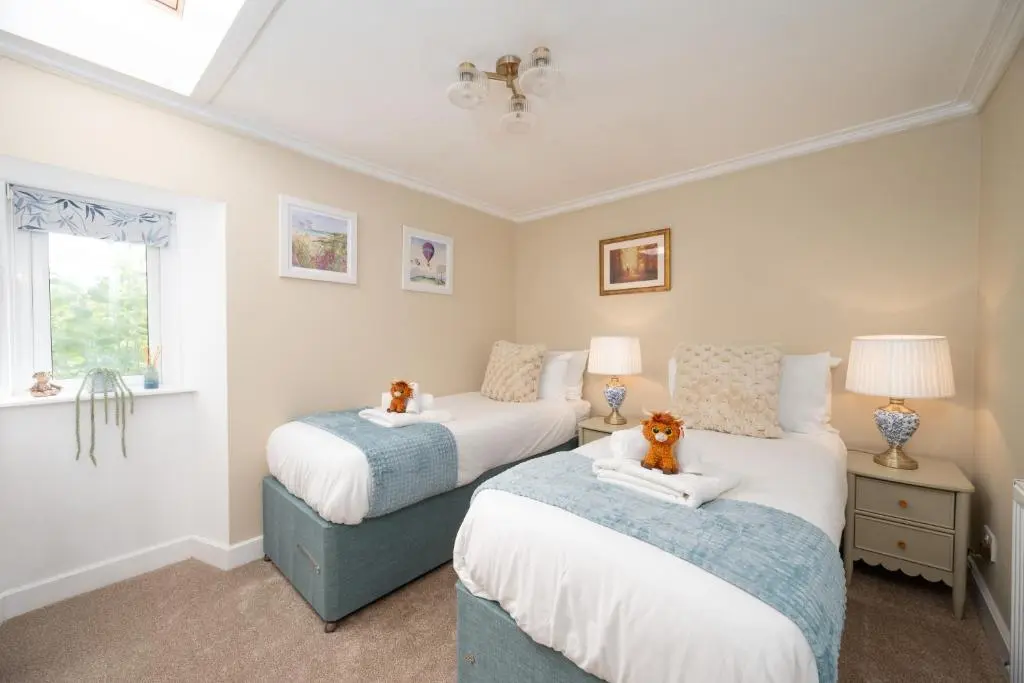 two beds with stuffed animals on them in a bedroom at The Garden Cottage with Hot Tub in Portsoy