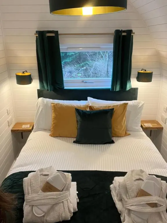 a bedroom with a large bed with a window at Rosevalley luxury Glamping grouse pods in Cawdor