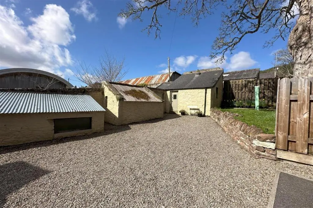 a yard with a building and a fence at Tweed Apartment, Golspie in Golspie