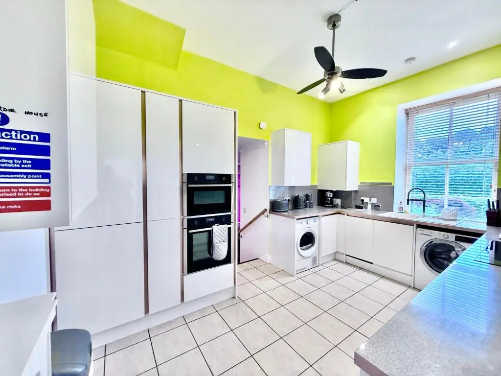 a kitchen with white appliances and a ceiling fan at Spacious Iconic Lesmurdie House 2 bed, free WiFi and Parking in Elgin