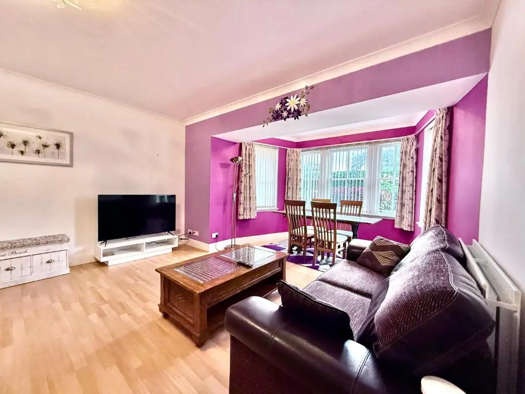 a purple living room with a couch and a tv at Spacious Iconic Lesmurdie House 2 bed, free WiFi and Parking in Elgin