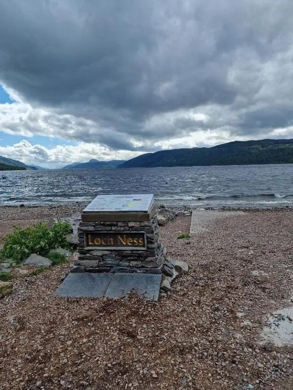 a sign on the shore of a body of water at Failte Stay in Inverness
