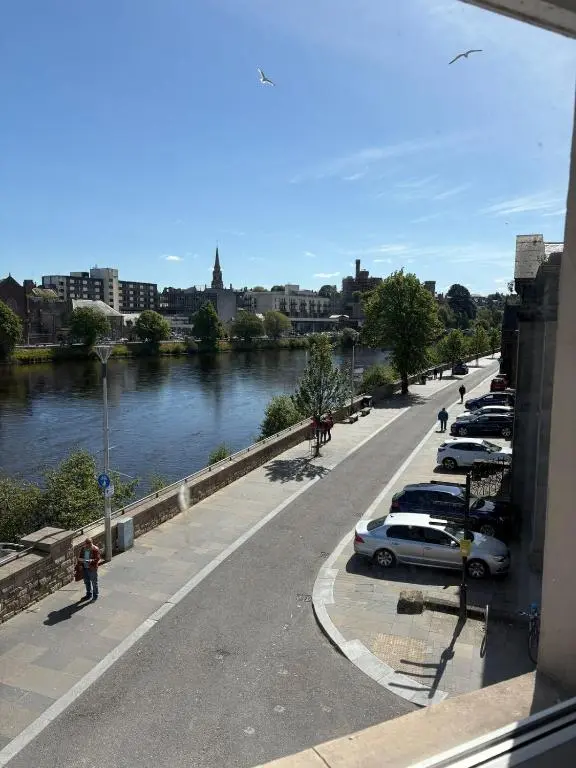 a parking lot with cars parked next to a river at River-View Loft, sleeps 4, with parking in Inverness