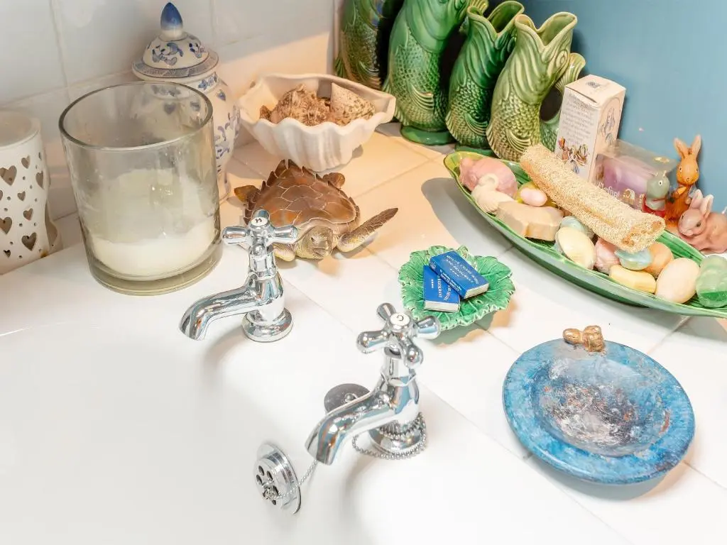 a bathroom sink with two faucets and a plate of food at Little Tarbet in Dornoch