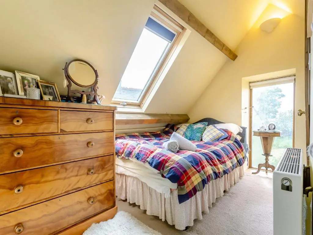 a bedroom with a bed with a dresser and a window at Little Tarbet in Dornoch